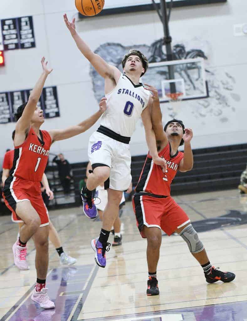 Photo - Madera South’s Daniel Vasquez drives the lane to score against the Kerman Lions. He scored 21 points in the loss.
