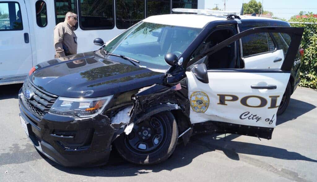 Photo - Madera Police Chief Dino Lawson looks at a wrecked 2018 Madera police SUV recently struck and totaled by a female driver alleged to be DUI and three times over the legal limit for alcohol.