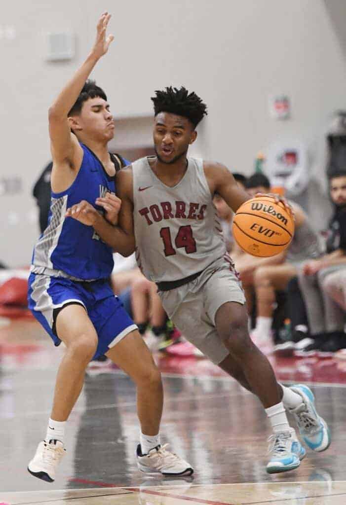 Photo - Matilda Torres’ Arturo Corona Jr. drives around a Sanger West defender to score two of his game-high 19 points. He scored 14 of those in a second half comeback. 