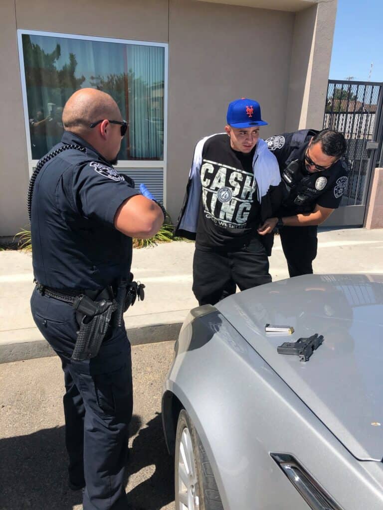 Photo - David Michael Rocha, 26, is arrested on charges of possession and sales of illegal drugs and the possession of a concealed weapon Saturday afternoon near 4th Street and Gateway Drive.