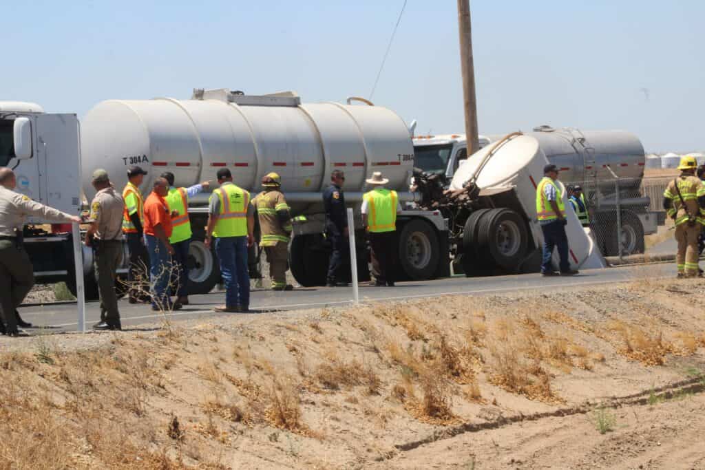 Photo - City and county officials take a look at a trailer that fell into a sinkhole on Avenue 13  on Monday afternoon.