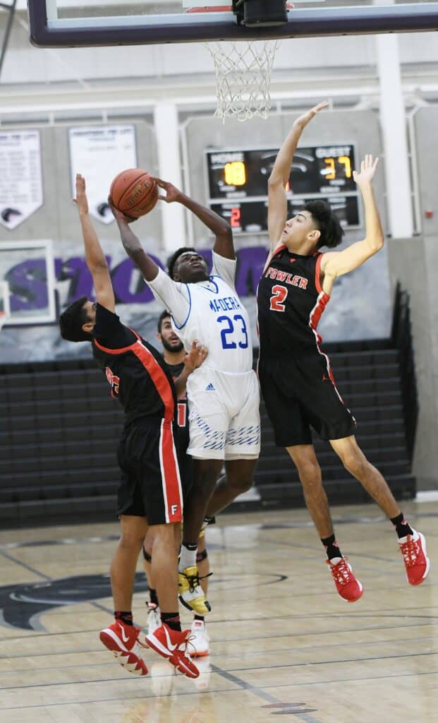 Photo - Madera’s Kecian Primes drives the lane against two Fowler defenders to score two of his team-high 15 points in a loss Thursday.