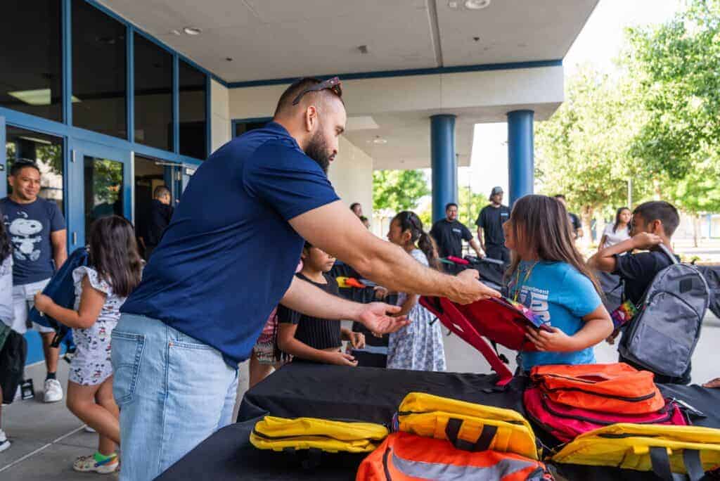 Photo - More than 130 students at Cesar Chavez Elementary receive free backpacks and school supplies during a giveaway Tuesday morning.