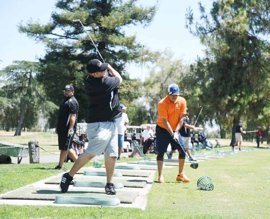Photo - Golfers hit the practice range to get ready for Beau Miracle’s golf tournament to benefit Disabled American Veterans.