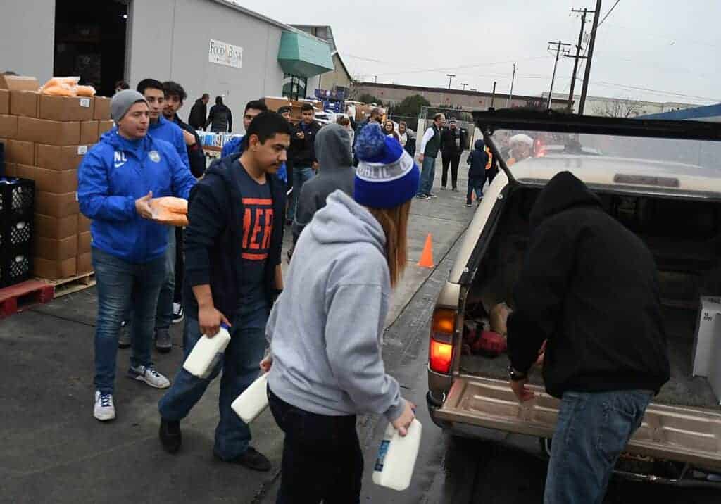 Photo - Volunteers distribute holiday food boxes to 400 recipients in a drive thru line on Saturday. An addition 100 boxes were made to be distributed to those or other agencies in need.