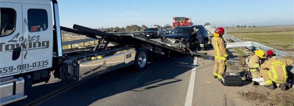 Photo - A guardrail is getting repaired while a Ford Explorer is prepared to be loaded onto the tow truck Tuesday after a DUI crash on Road 27.
