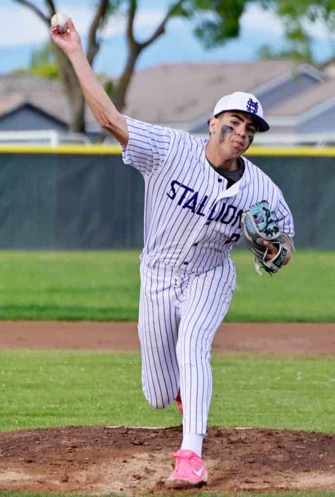 Photo - Madera South’s Gilbert Moisa throws a pitch during a wet and cold Friday night loss to the Sanger West Hornets.