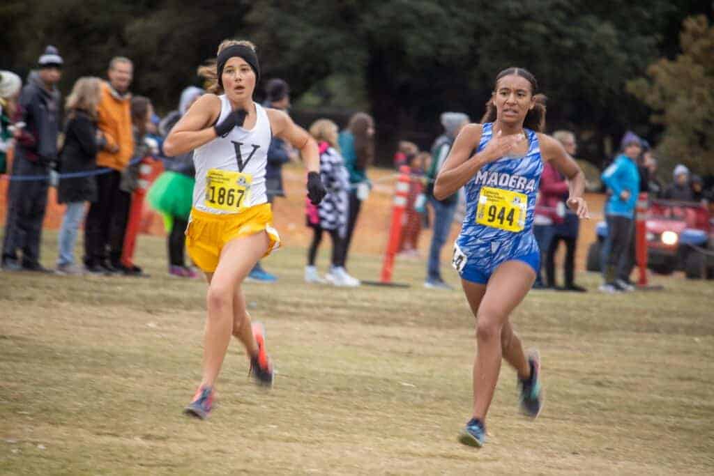 Photo - Madera’s Unique Ford, right, heads to the finish line in the Div. II CIF State Cross Country championships race with a personal best time. Ford placed sixth in the state and beat her personal record by more than 30 seconds.