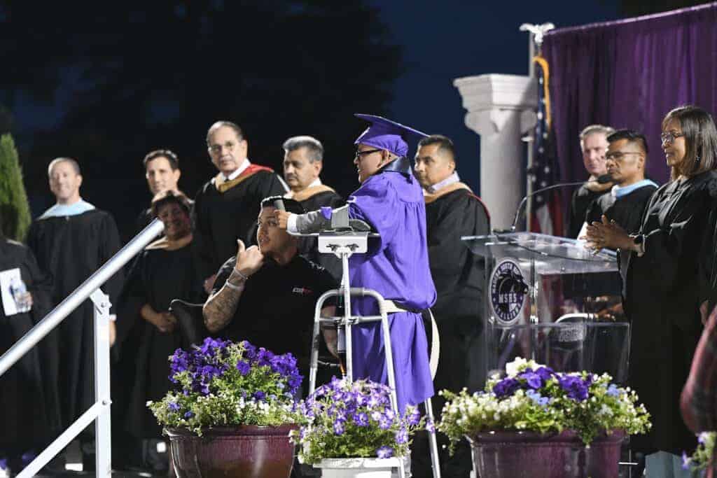 Photo - Madera South High graduate Efren Ramirez Vasquez walks publicly for the first time with some assistance to receive his diploma. He will be attending Fresno State in the Fall. He received a Bi-Literacy medal and the Ken Taylor Boy of the Month award.
