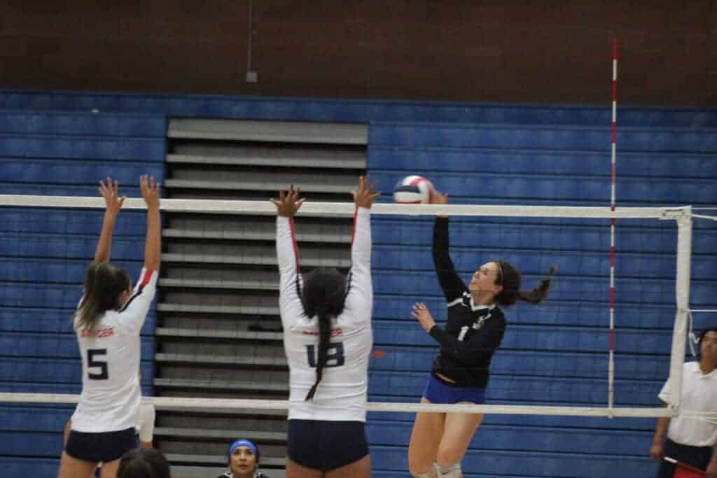 Photo - Madera’s Lilly Ascencio attacks Sanger blockers during a four-set win Thursday.