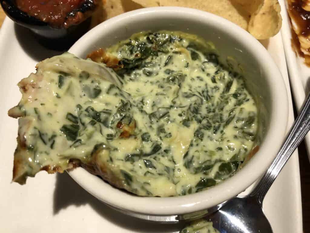 Photo - Dip pita chips into a hot dish of spinach artichoke dip for a real treat.
