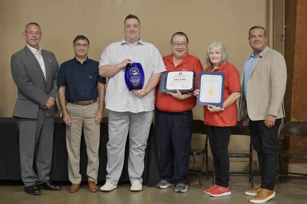 Photo - Members of Madera Chamber of Commerce board of directors John Copland, left, Zahid Bhatti, second from left, and Joe Doyland, right, present a Lifetime Achievement Award in memory of Tami Jo Nix to Rick Dorris, holding vase, and fellow colleagues Tyler Takeda and Nancy Simpson.