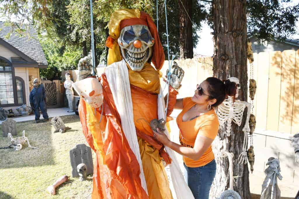 Photo - Esmeralda Garcia hangs a spooky giant clown in the front yard of her Halloween House at 824 Claremont Dr.