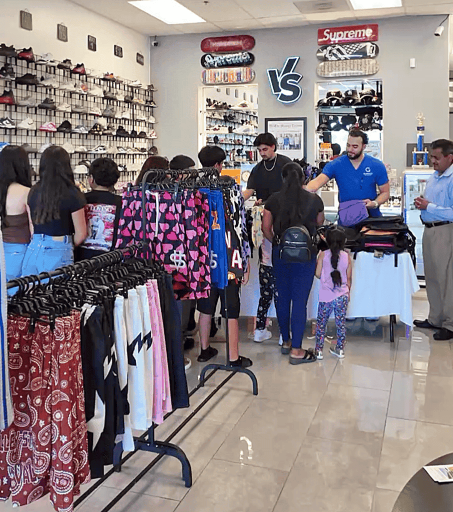 Photo - Valley Stealz co-owner Ali Escheik hands out one of about 100 backpacks the store gave away last week.