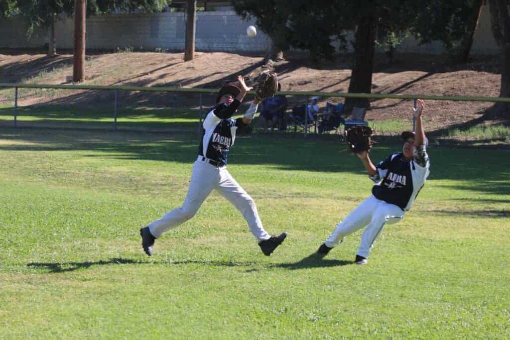 Photo - Madera American second baseman Jorge Gutierrez reaches up to make the catch in front of diving right fielder Eric Gallegos during a victory Saturday over Reedley.