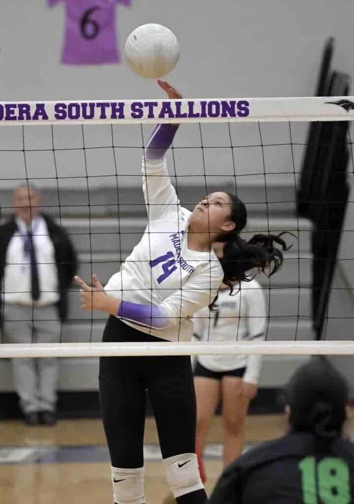 Photo - Madera South’s Maria Hernandez sends a kill past the Roosevelt block during Thursday’s match at Madera South.