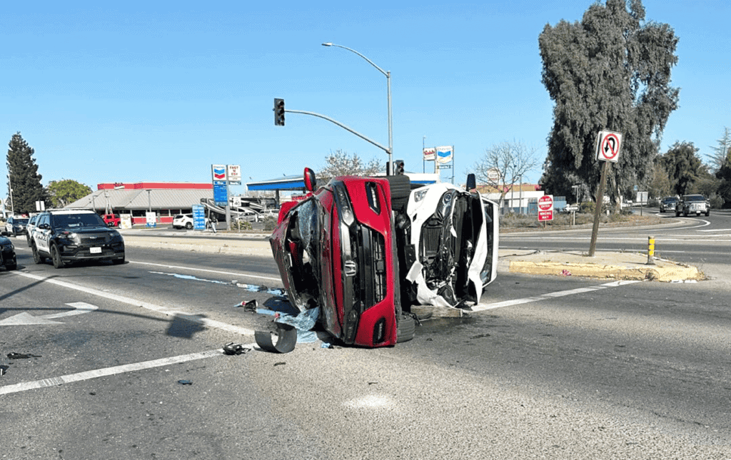 Photo - Two cars lay on its side after a three-vehicle crash stalled traffic on Cleveland Avenue near the southbound State Route 99 off ramp Saturday morning.