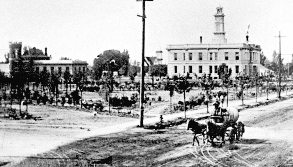 Photo - It didn’t take long for Courthouse Park to take shape after a fire in 1909 cleared the property of every building except the courthouse and jail. The water wagon can be seen fighting the dust on Yosemite Avenue a year later.