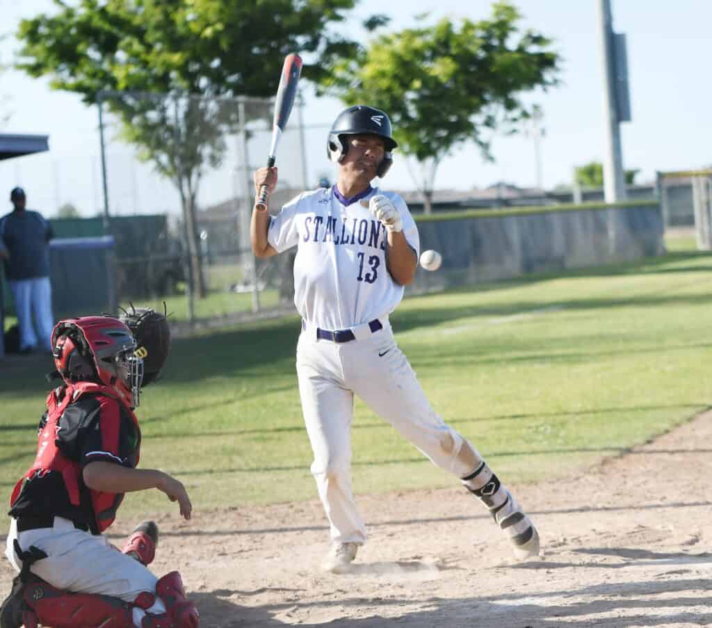 Photo - Madera South’s Elijah Tang unsuccessfully tries to get out of the way of a pitch to lead off the sixth inning. Tang’s hit by pitch led to a two-run rally for the Stallions in a 5-2 win Tuesday.