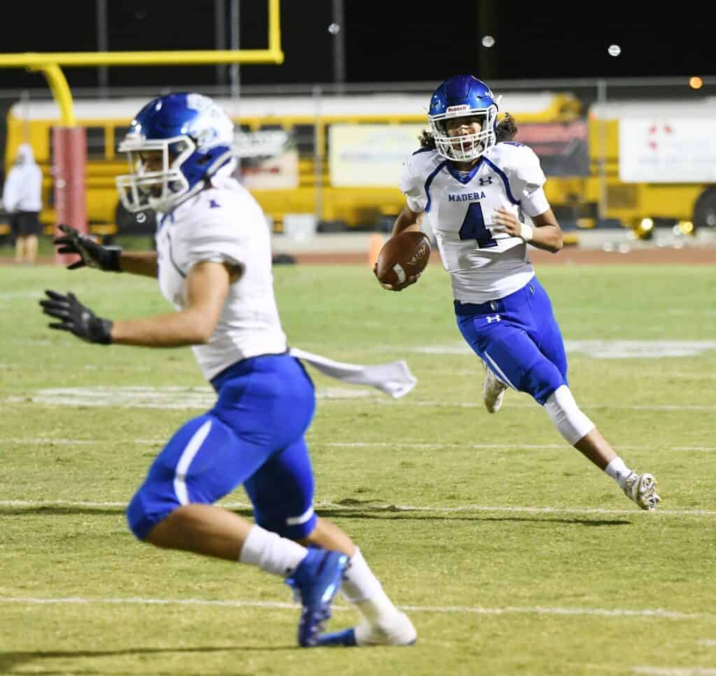 Photo - Madera quarterback David Zavala turns the corner during a run while Marco Lopez looks for someone to block.