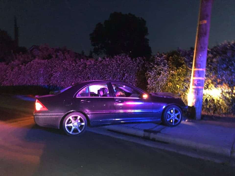 Photo - A Mercedes, riddled with bullet holes, sits abandoned with its engine still running after crashing into a pole on South Granada Drive near Merlot Avenue.