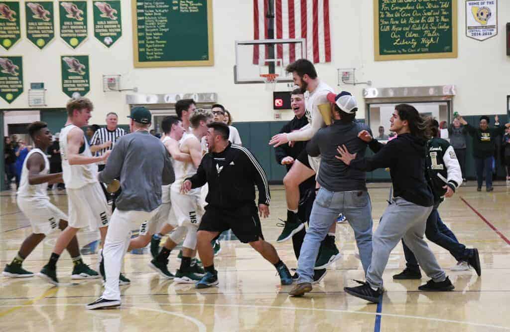 Photo - Members of the Liberty High School student body rushes the court to celebrate with the boys basketball team after an 80-73 victory over the defending two-time Valley Champions, California City, in the Div. V semifinals Wednesday.
