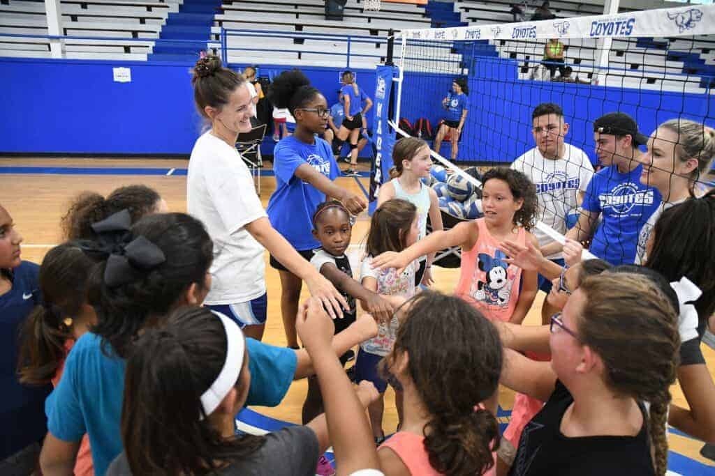 Photo - Coaches and campers get together for a break during the Elementary Skills Camp hosted by the Madera Coyote girls volleyball program and head coach Meghan Haas (white shirt on left).