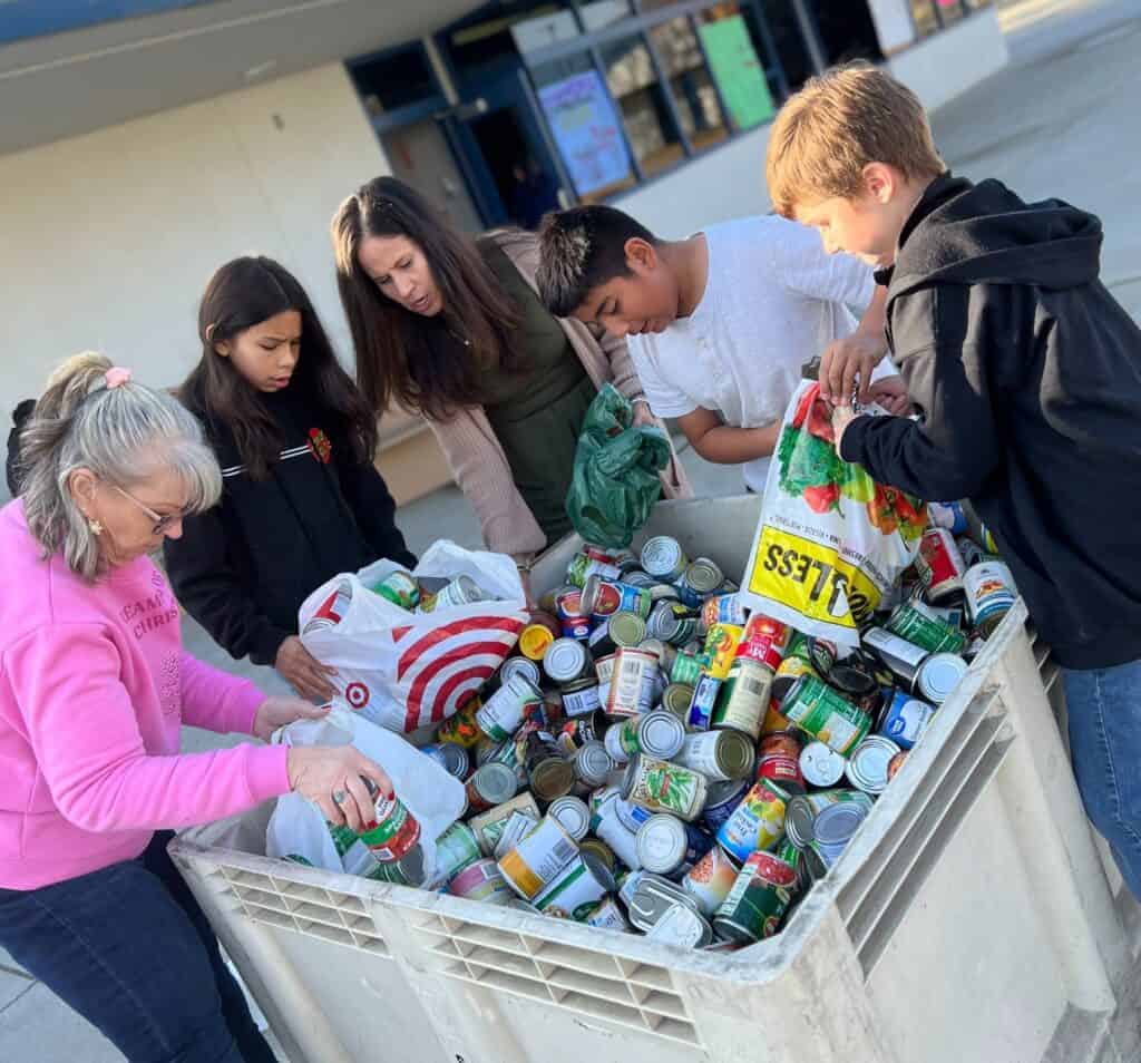 Photo - Pershing Elementary students show off the many cans of food collected during a drive this month.