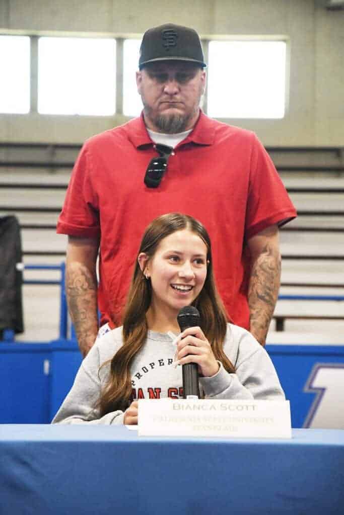 Photo - With father Bryan Scott watching, Madera’s Bianca Scott talks to the crowd during Madera High School’s Signing day for seven athletes that signed a National Letter of Intent.