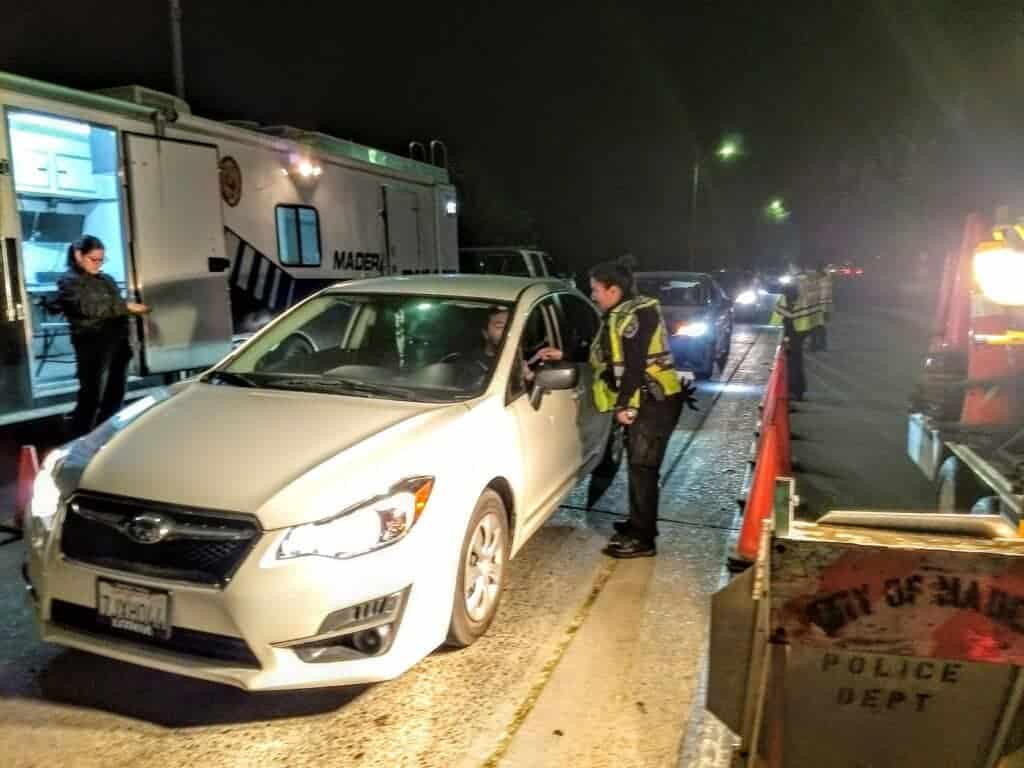 Photo - Madera police officers stop and speak with motorists in December on Gateway Drive at a driver’s license and sobriety checkpoint. The checkpoint netted two drivers allegedly under the influence of alcohol, among other violations.