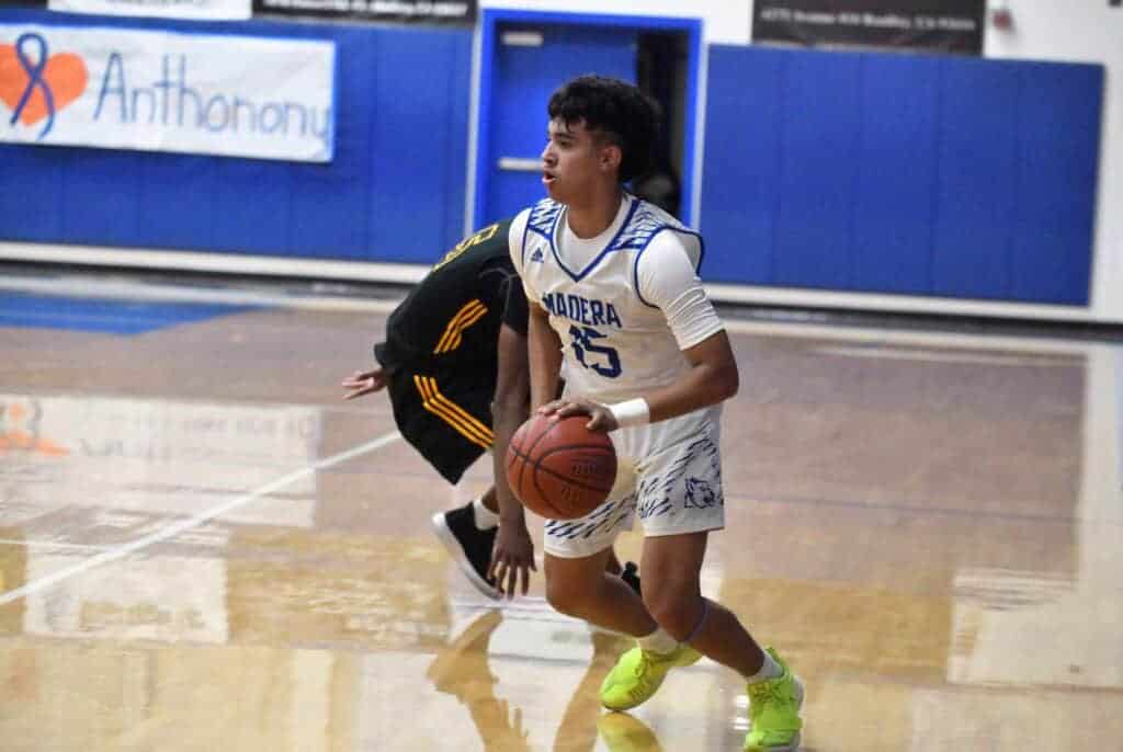 Photo - Madera’s David Monge dribbles past an Edison defender during Thursday’s home finalé loss to the Tigers.