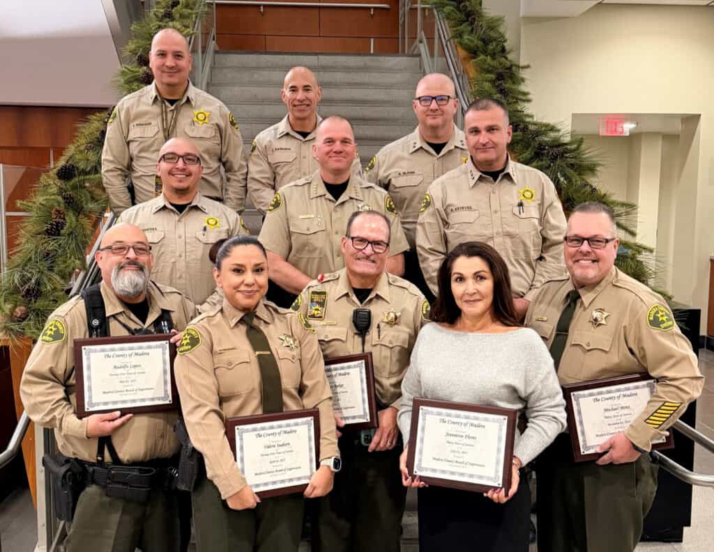 Photo of The Madera County Sheriff’s Office honors five long-time employees at a recent Board of Supervisors meeting. Receiving the honors are, front row, from left, Deputy Rudolfo Lopez, Lieutenant Valerie Seaborn, Deputy Jeffrey Barker, Senior Administrative Analyst Jeannette Flores, and Civil Unit Manager Mike Motz. Also representing the MCSO are, middle row, from left Lieutenant Benjamin Mendoza, Sheriff Tyson Pogue, and Undersheriff Brian Esteves. Back row, from left, are Captain Christopher Rodriguez, Lieutenant Zachary Zamudio and Assistant Sheriff Robert Blehm.