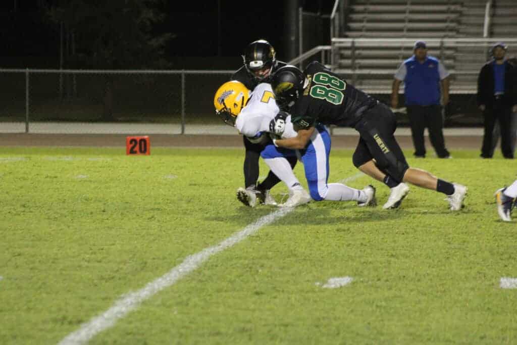 Photo - Liberty linebackers William Bucaroff (88) and Wyatt Roth tackle Corcoran quarterback Jayden Mustain for a loss during Friday’s 67-19 victory over the Panthers.