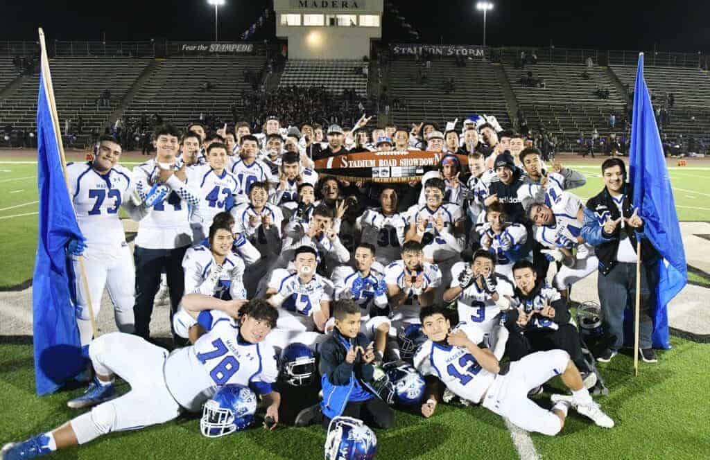 Photo - The Madera Coyotes football team celebrates with the Bandsaw Trophy after winning its ninth Stadium Road Showdown on Friday. The Coyotes scored two touchdowns in the fourth quarter for a 28-7 victory in Memorial Stadium.