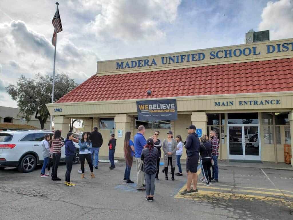 Photo - Parents and children stand outside the Madera Unified School District main office Wednesday after voicing concerns inside about rumors of a student threat against Howard Elementary School.