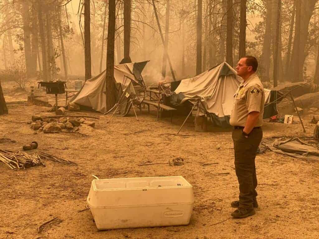 Photo - Madera County Sheriff Tyson Pogue looks over a campsite at Mammoth Pool to see the damage and understand what would be required to retrieve vehicles and personal property. “It was quite overwhelming and somewhat emotional to see,” Pogue, a lifelong Madera County resident, said. “I can’t even imagine being there as the fire ripped through that area. The scene I found can only be described as eerily apocalyptic.”