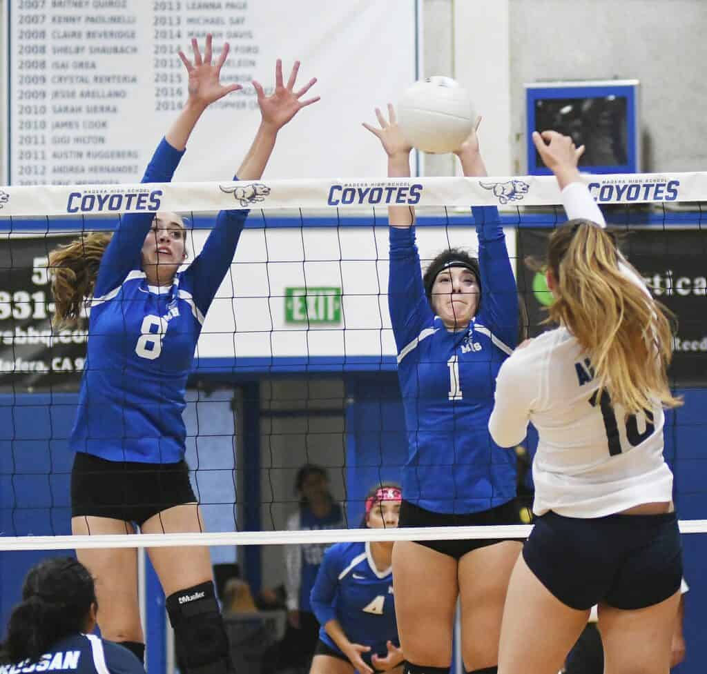 Photo - Madera’s Hallie Page (8) and Lillith Ascencio rise up to block a Bullard hit Tuesday in Joe Flores Gym. Page led the Coyotes with 11 kills in a sweep over the Knights and remain undefeated in the County/Metro Athletic Conference.