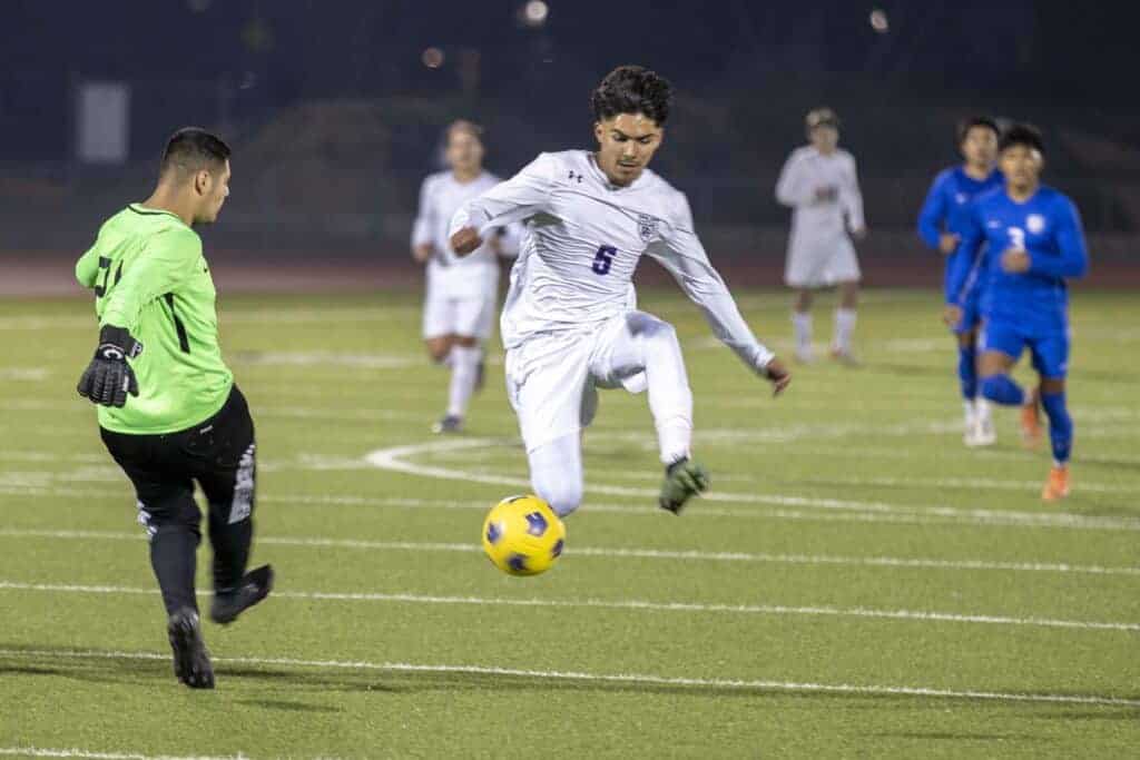 Photo - Madera South’s Ulysses Vega tries to get in the way of Madera goalkeeper Jesse Cuevas’ kick down the field. Vega scored the first goal in a 2-1 victory over the Coyotes.