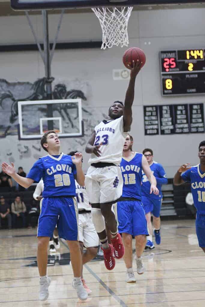 Photo - Madera South’s Hakeem Primes drives in for a layup during Friday’s loss to the Clovis Cougars. Primes led the Stallions with 14 points and nine rebounds.