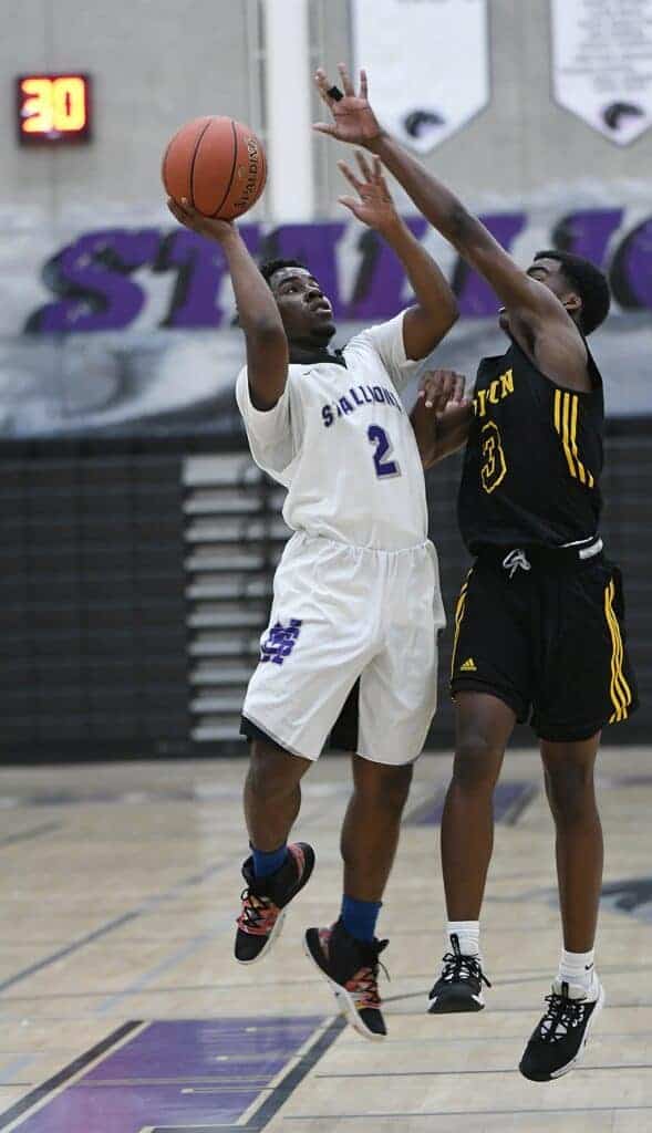 Photo - Madera South’s Jayshawn Thomas tries to shoot over the hands of an Edison defender to score two of his game-high 24 points in Friday’s loss.