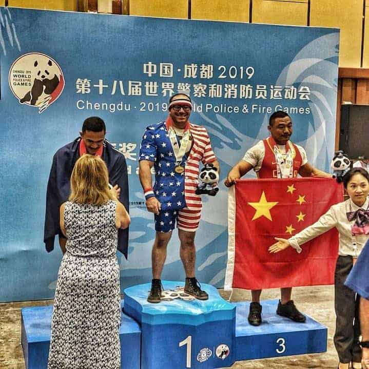 Photo - Ryan King, Deputy with the Madera County Sheriff’s Office poses at the top of the medal stand for his gold place finish at the 2019 World Police and Fire Games.