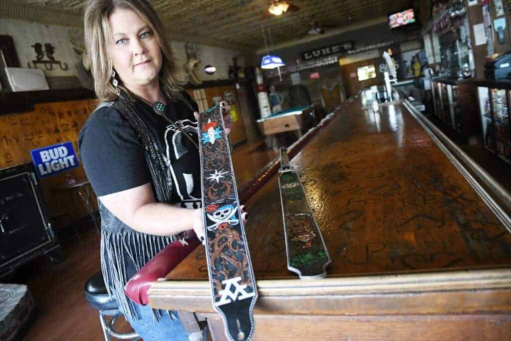 Photo - Dana Elliott of Buckin Buckarette guitar straps displays a custom ordered guitar strap she made for country singer Ashley McBryde.