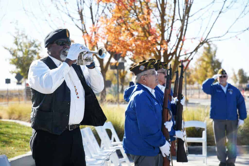 Photo - Reggie King plays TAPS following a Rifle Salute to Fallen Comrades by members of Kerman VFW Post 8470.