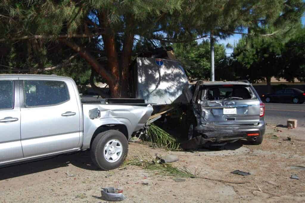 Photo - Vehicles that had been parked sit demolished in the front yard of a home in the 2300 block of Sunset Avenue Sunday morning after a 24- year-old driver, alleged to be DUI, lost control and crashed into the parked SUV, a pickup truck and a landscaping trailer before overturning.