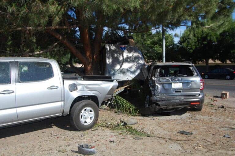 Speeding driver trashes parked car, truck, trailer