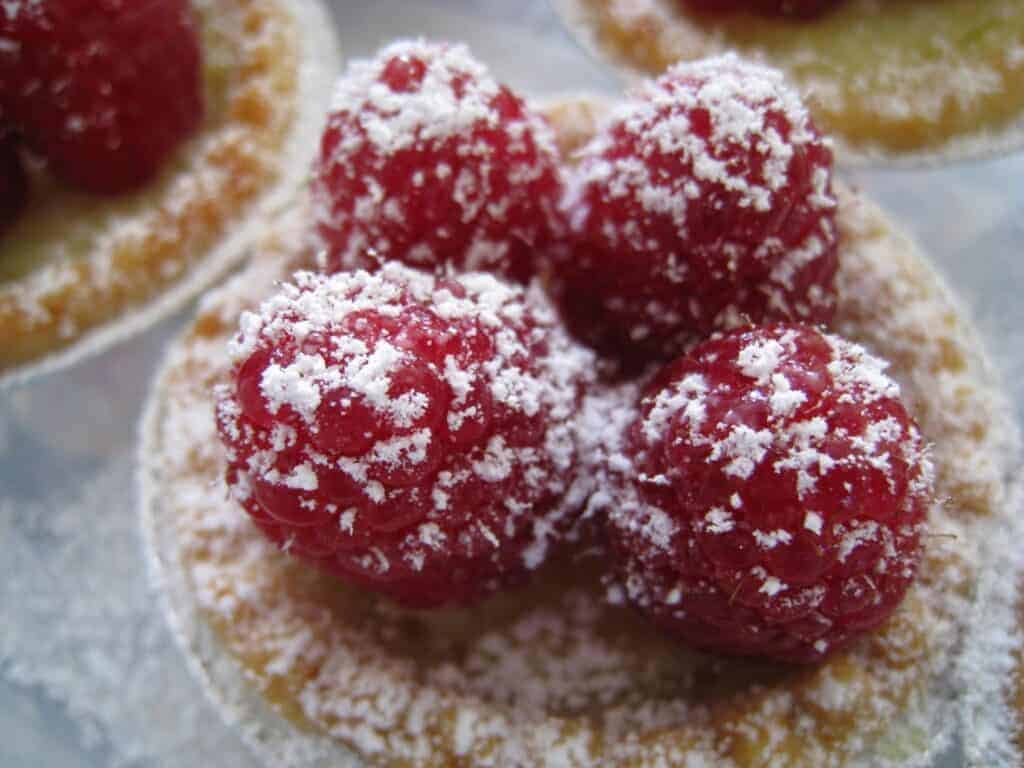 Photo - Use homemade or store-bought lemon curd to make small tarts, and top with raspberries.