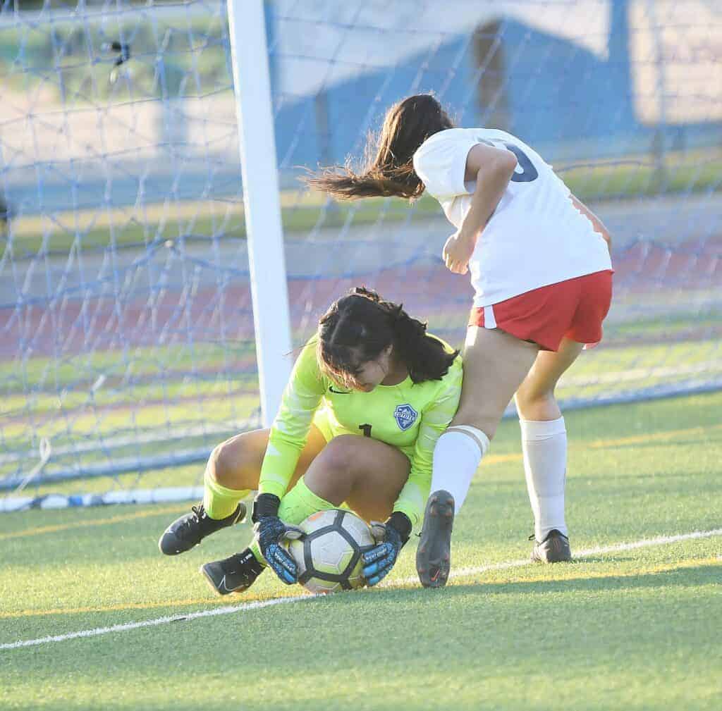 Photo - Madera Coyotes goalkeeper Arianna Ornelas keeps the ball away from a Sanger attacker during Thursday’s match.