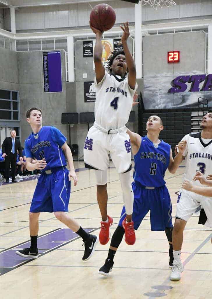 Photo - Madera’s Joel Galvan drives the lane for two of his six points in Tuesday’s playoff win over Caruthers.