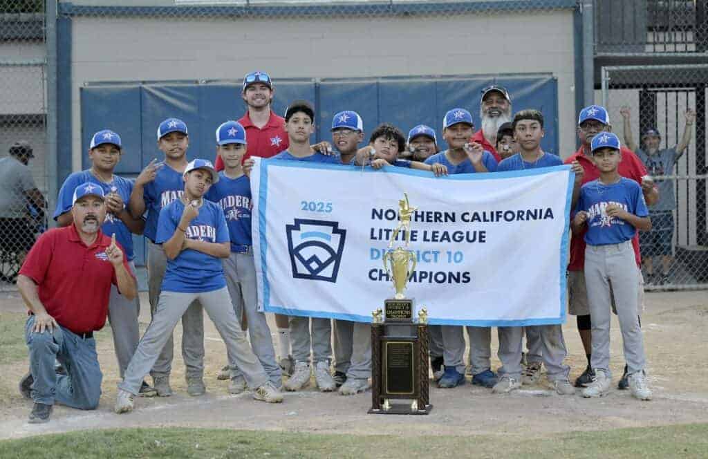 Photo - The Madera American Little League 10-12-year-old All-Stars celebrate at home plate, with league President Scott Varela (bottom left), after defeating Madera National, 7-4 on Thursday to win the District 10 championship. 