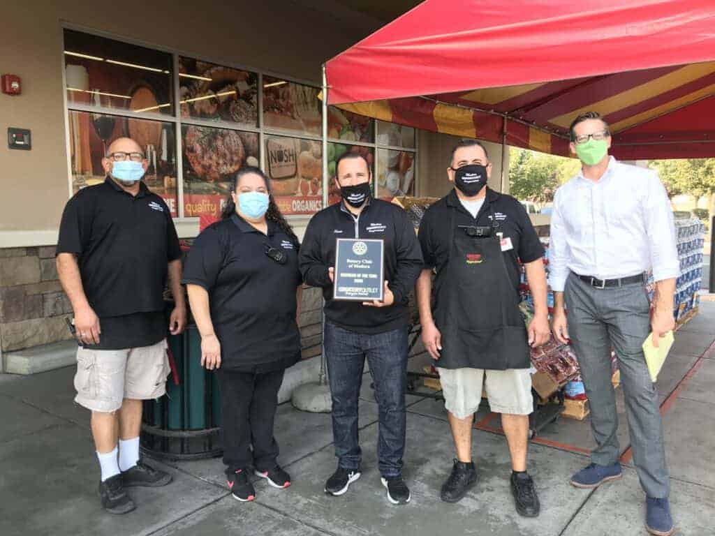 Photo - Grocery Outlet employees, from left, Rick Martinez, Margie Rivera, Owner Sean Tharp, Miguel Hernandez and Madera Rotary Business of the Year Chair Brian Bolstad celebrate the store being awarded business of the year.